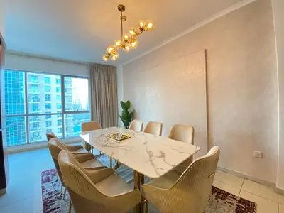a dining room with a table and chairs at Durrani Homes - The Residences 5BR Besides Dubai Mall with Burjkhalifa and Fountain view in Dubai