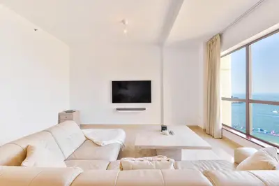 a living room with white furniture and a large window at Deluxe Retreat In JBR - Million Dollar View - Balcony in Dubai