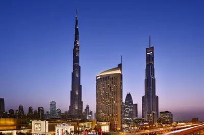 a view of a city skyline at night at Fashion Avenue Dubai Mall Highest Floor Burj Khalifa View Residence- Formerly Address Dubai Mall in Dubai