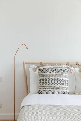 a white bed with white pillows and a lamp at Frank Porter - Al Nabat in Dubai