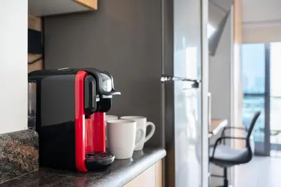a red and black suitcase sitting on a counter with cups at Chic JLT Studio, Lake View, Pool, Metro Access in Dubai
