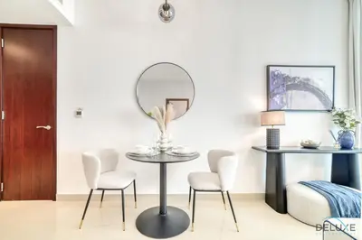 a dining room with a table and chairs and a mirror at Harmonious 1BR at 29 BLVD Tower 1 Downtown Dubai by Deluxe Holiday Homes in Dubai