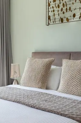 a bedroom with a bed with pillows at Frank Porter - Al Sahab 2 in Dubai