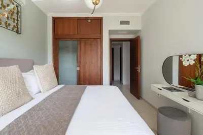 a bedroom with a large bed and a mirror at Frank Porter - Al Sahab 2 in Dubai