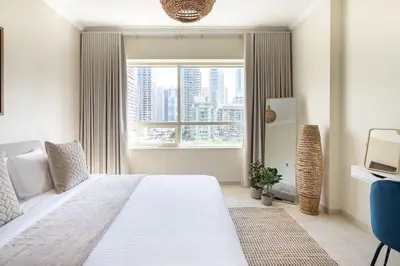 a bedroom with a large white bed and a window at Frank Porter - Al Sahab 2 in Dubai