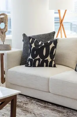 a white couch with black and white pillows in a living room at Frank Porter - Al Sahab 2 in Dubai