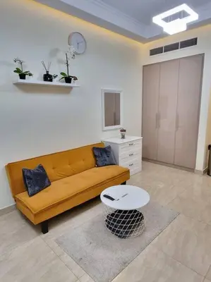 a living room with a yellow couch and a table at Premium Lovely Studio with Balcony in Dubai in Dubai
