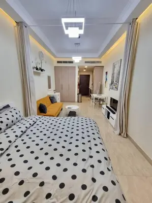 a bedroom with a large bed and a living room at Premium Lovely Studio with Balcony in Dubai in Dubai