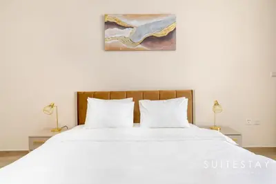 a bedroom with a large white bed with two lamps at Prestigious Studio With High Quality Interiors in Dubai