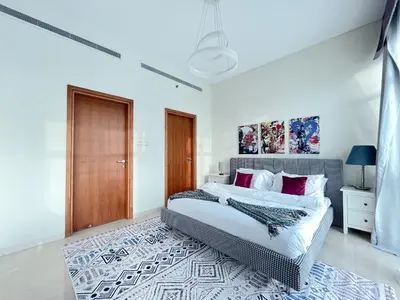 a bedroom with a large bed with red pillows at Trophy Stays - Vibrant Work-Friendly Studio in Business bay in Dubai