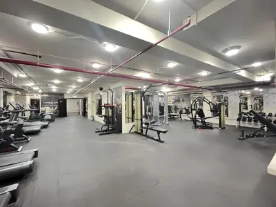 a gym with rows of treadmills and machines at Trophy Stays - Vibrant Work-Friendly Studio in Business bay in Dubai