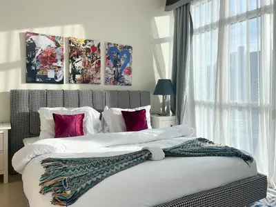 a bedroom with two beds with white and pink pillows at Trophy Stays - Vibrant Work-Friendly Studio in Business bay in Dubai