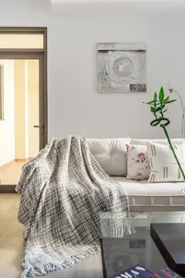 a living room with a white couch with a blanket on it at The Smart Concierge - Amwaj 4 in Dubai