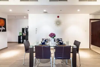 a dining room with a glass table and chairs at The Smart Concierge - Amwaj 4 in Dubai