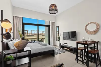 a bedroom with a bed and a desk and a television at Mesmerizing nicely furnished studio in JVC in Dubai