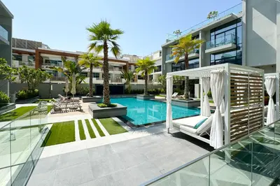 a swimming pool with a gazebo next to a building at Mesmerizing nicely furnished studio in JVC in Dubai