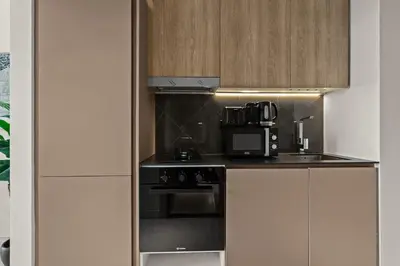 a kitchen with a stove and a microwave at Mesmerizing nicely furnished studio in JVC in Dubai