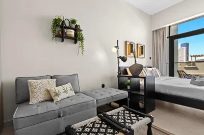 a living room with a couch and a bed at Mesmerizing nicely furnished studio in JVC in Dubai