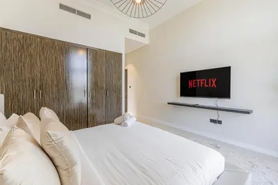 a bedroom with a bed and a tv on the wall at Daniels Golf Course 5BR Villa with Private Pool in Dubai