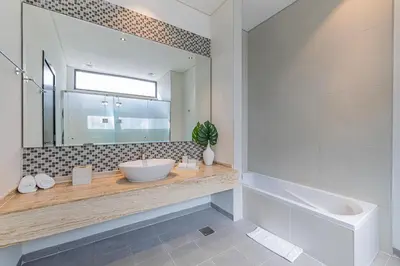 a bathroom with a sink and a tub and a mirror at Daniels Golf Course 5BR Villa with Private Pool in Dubai