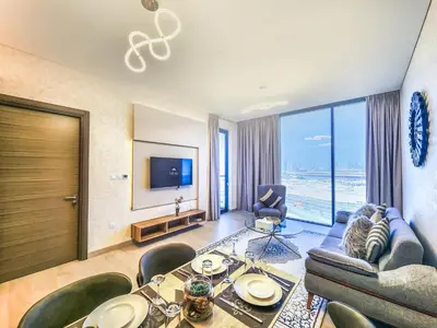 a living room with a table and chairs and a television at STAY BY LATINEM Luxury 1 BR Holiday Home OPA 1601 near Burj Khalifa in Dubai