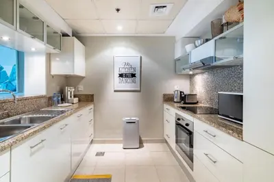 a kitchen with white cabinets and a sink at GuestReady - Oliver Twist in Dubai
