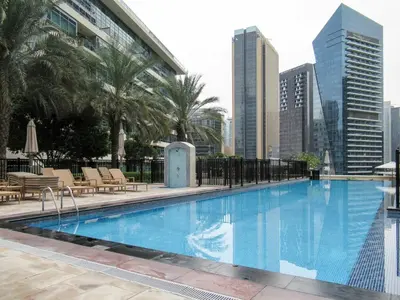 a large swimming pool with a city skyline in the background at GuestReady - Oliver Twist in Dubai