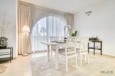 a white dining room with a white table and chairs at Serene 1BR at Murjan 2 JBR by Deluxe Holiday Homes in Dubai