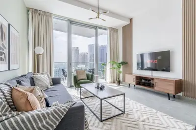 a living room with a couch and a tv at GuestReady - Modern Mirza with Marina View in Dubai