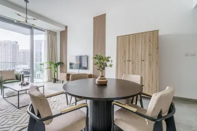 a living room with a table and chairs at GuestReady - Modern Mirza with Marina View in Dubai