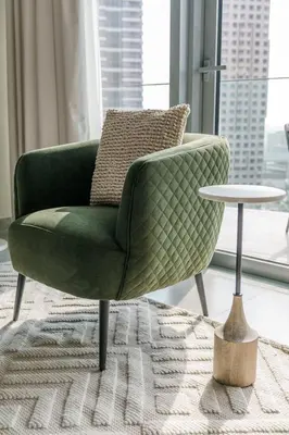 a green chair and a table in a living room at GuestReady - Modern Mirza with Marina View in Dubai