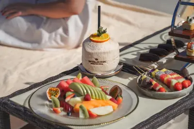 a table with two plates of fruit and a drink at NH Collection Dubai The Palm in Dubai