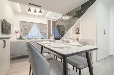 a dining room with a table and chairs and a bed at Boutique Luxury Living near Palm Jumeirah in Dubai