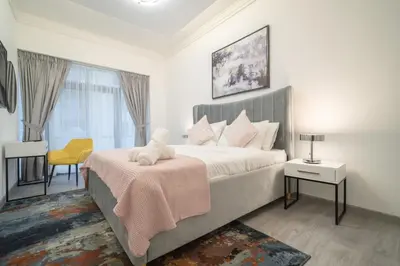 a bedroom with a large bed with a pink blanket at Boutique Luxury Living near Palm Jumeirah in Dubai