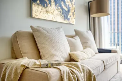 a living room with a couch with a blanket on it at Welcome Home at The Address Marina 1BR in Dubai