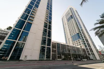 two tall buildings in a city with a street at Vacay Lettings - Waterfront Studio with great Dubai Canal view in Dubai