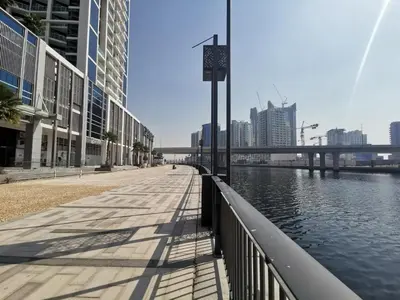 a walkway next to a body of water with buildings at Vacay Lettings - Waterfront Studio with great Dubai Canal view in Dubai