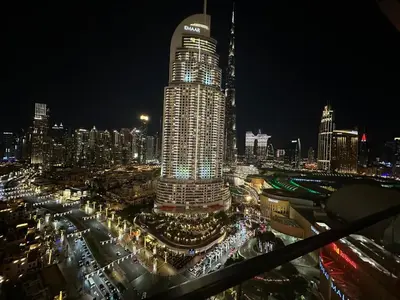 a lit up city at night with a tall building at Holidays R Us Royal View in Dubai