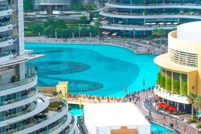 a blue pool in a city with tall buildings at Holidays R Us Royal View in Dubai