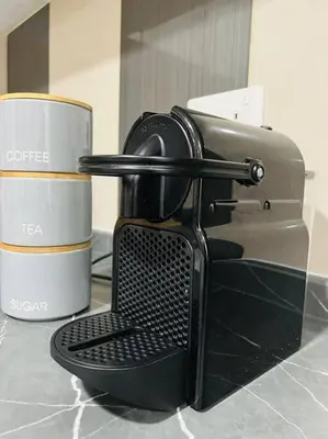 a coffee maker next to two cups on a counter at Ocean Heights - Spacious 1 Bedroom Apartment with Sea View, Gym & Free Parking in Dubai