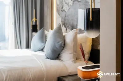 a bedroom with a white bed with blue pillows at OSTAY -Address Dubai Mall - The Residence in Dubai