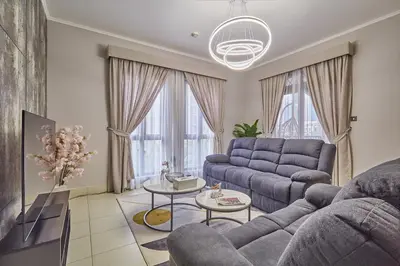 a living room with a blue couch and tables at Golden homes Burj khalifa view Yansoon 1BR heart & Soul old town Beside Dubai mall Burjh Khalifa in Dubai