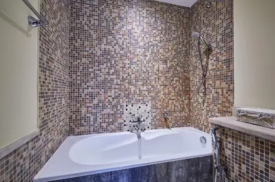 a white bath tub in a tiled bathroom at Golden homes Burj khalifa view Yansoon 1BR heart & Soul old town Beside Dubai mall Burjh Khalifa in Dubai