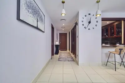 a hallway with a clock on the wall at Golden homes Burj khalifa view Yansoon 1BR heart & Soul old town Beside Dubai mall Burjh Khalifa in Dubai