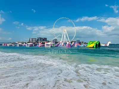a beach with a ferris wheel in the water at Spacious 2BD in Amwaj JBR near the beach in Dubai