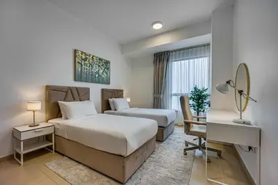a hotel room with two beds and a desk at Spacious 2BD in Amwaj JBR near the beach in Dubai
