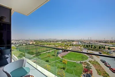 a balcony with a view of a park at Bright and spacious apartment in DAMAC HILLS in Dubai