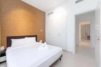 a bedroom with a large white bed in a room at Stunning 4 bedroom townhouse in Townsquare in Dubai