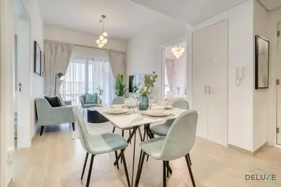 a dining room and living room with a table and chairs at Serene 2BR at The Nook Wasl Gate Jebel Ali by Deluxe Holiday Homes in Dubai