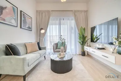 a living room with a couch and a tv at Serene 2BR at The Nook Wasl Gate Jebel Ali by Deluxe Holiday Homes in Dubai